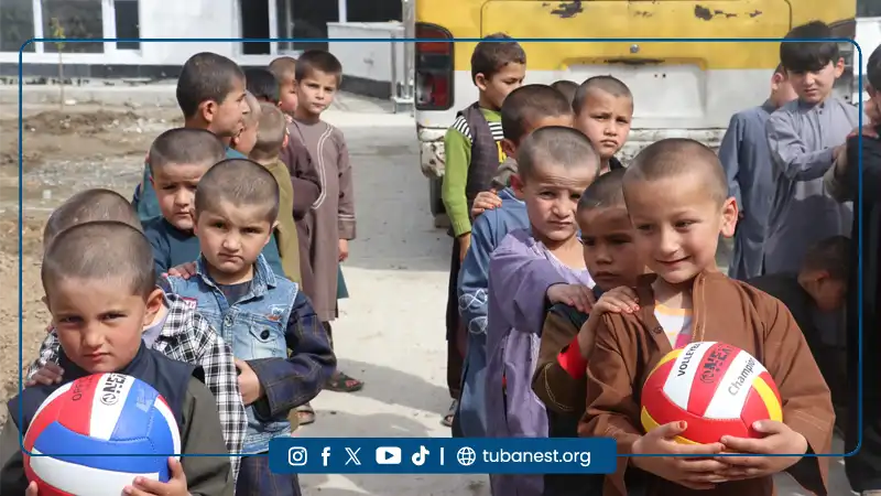 Children of Tuba Nest participating in organized sports activities including warm-up exercises and football training in Takhar province, Afghanistan.